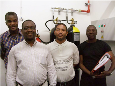 IT Team of MOHSS posing in the Data Center infront of the gas bottles, part of the Fire Detection and Suppression System